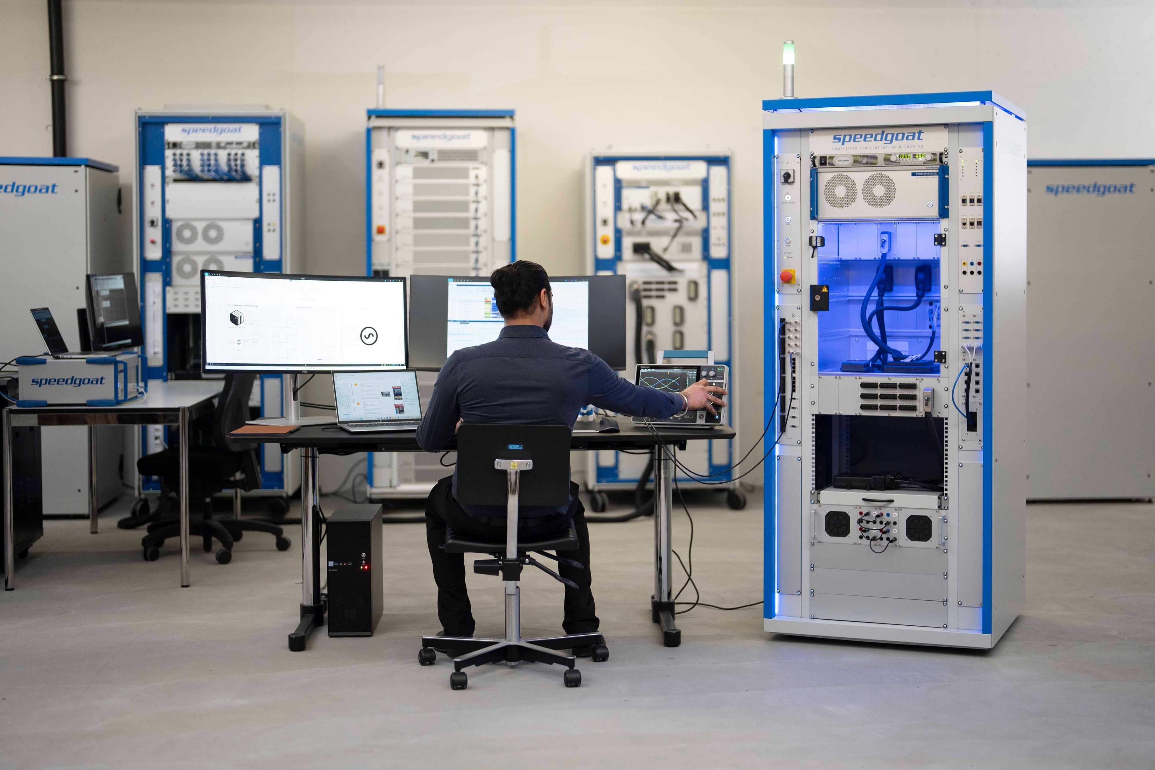 Person adjusting electronic test equipment at a laboratory workstation.